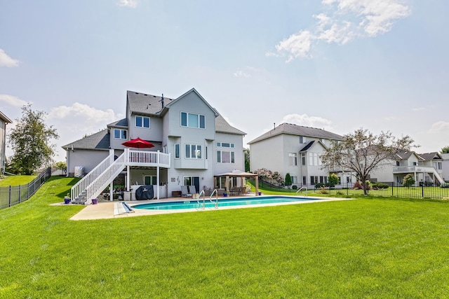 back of house featuring a patio area, a swimming pool side deck, and a yard