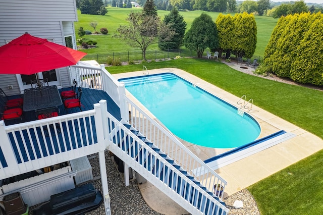 view of swimming pool with a lawn and a deck