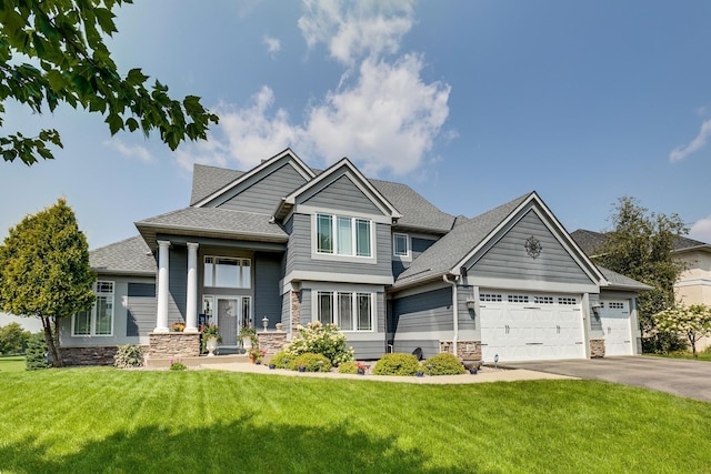 craftsman inspired home featuring a garage and a front lawn