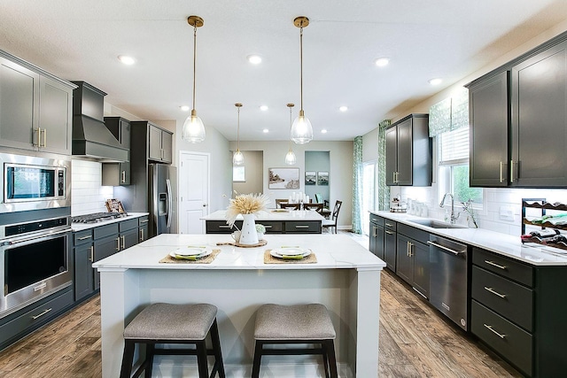 kitchen with custom exhaust hood, stainless steel appliances, a center island, sink, and dark hardwood / wood-style floors