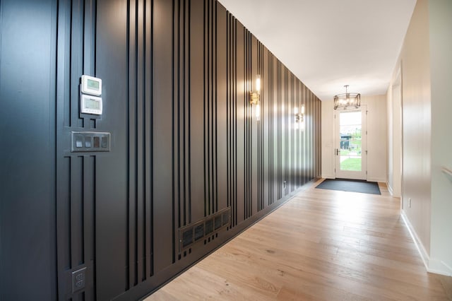 hall with hardwood / wood-style floors and a chandelier