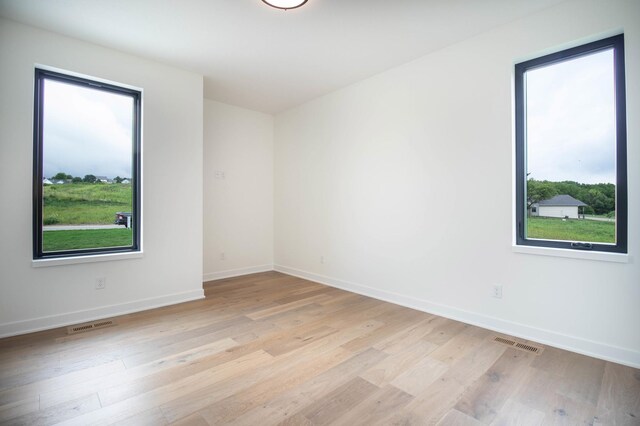 empty room with light hardwood / wood-style flooring