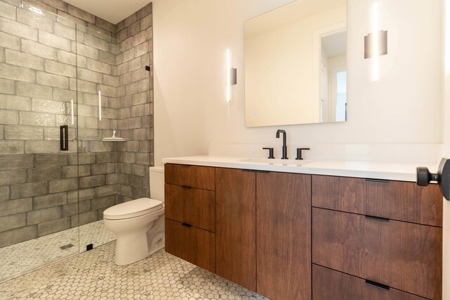 bathroom featuring toilet, walk in shower, tile patterned flooring, and vanity