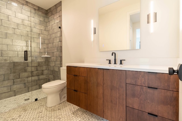 bathroom with vanity, a shower with door, toilet, and tile patterned floors