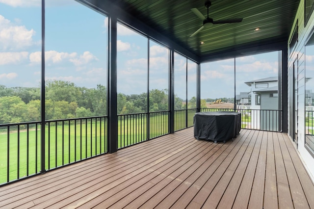 unfurnished sunroom with ceiling fan