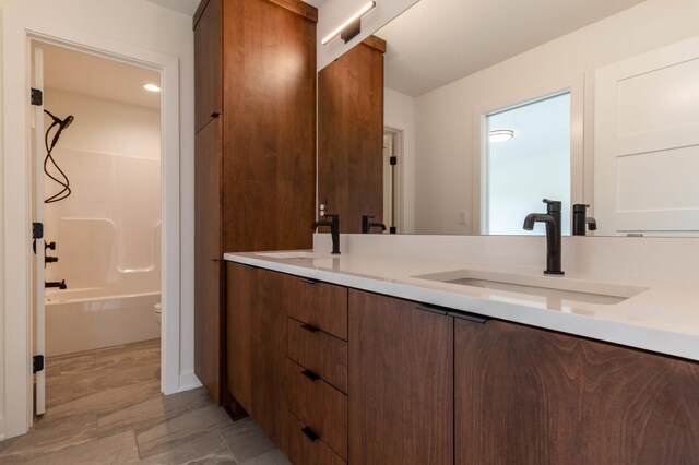 full bathroom with tile patterned flooring, double vanity, tub / shower combination, and toilet