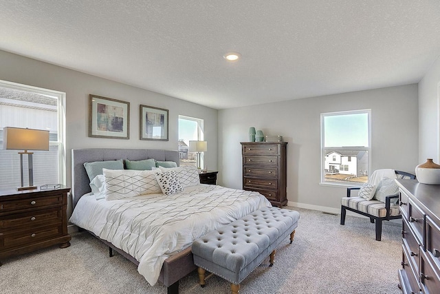 bedroom with a textured ceiling and light colored carpet