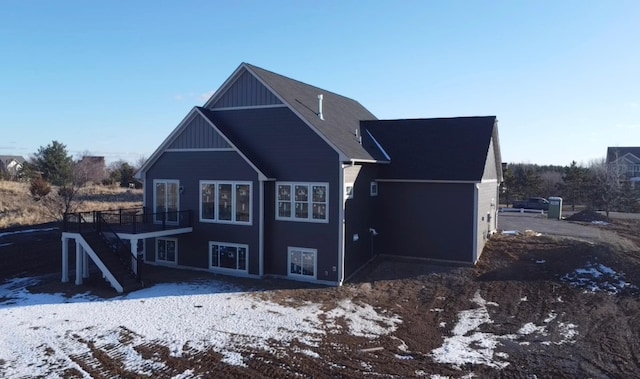 snow covered house featuring a wooden deck