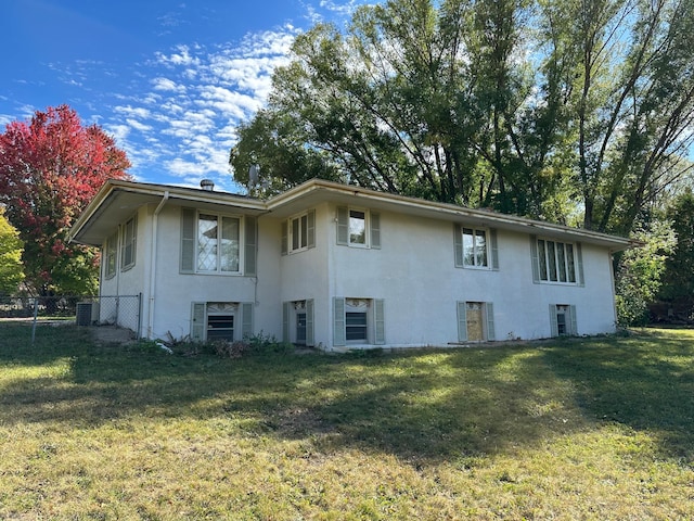 back of house with a lawn and central AC