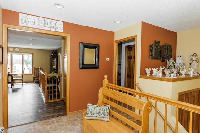 corridor featuring light hardwood / wood-style flooring and a textured ceiling