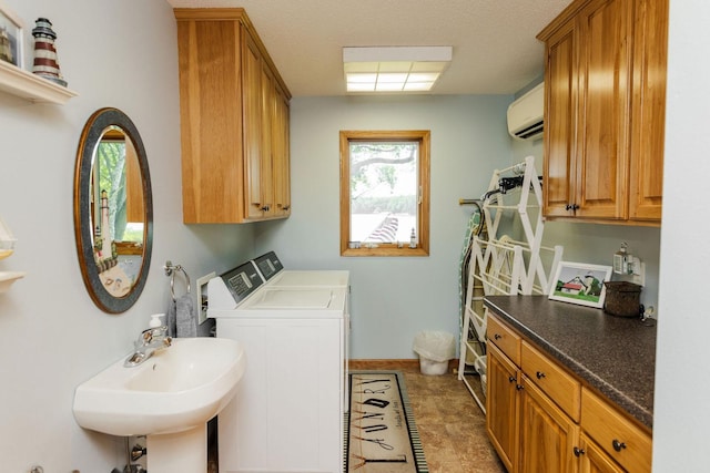 laundry room with cabinets, a wall unit AC, separate washer and dryer, and sink