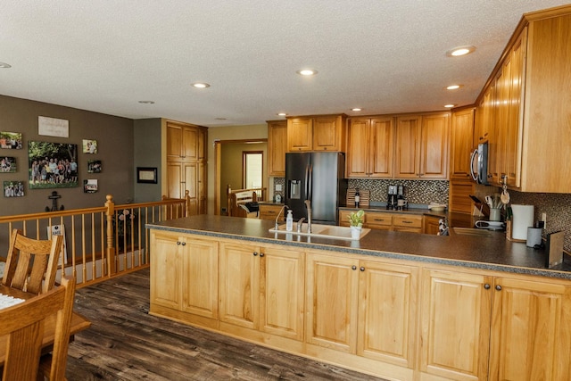 kitchen with decorative backsplash, dark hardwood / wood-style flooring, stainless steel appliances, a textured ceiling, and sink