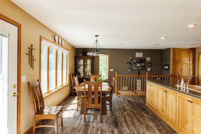 dining area with a textured ceiling, dark wood-type flooring, and sink