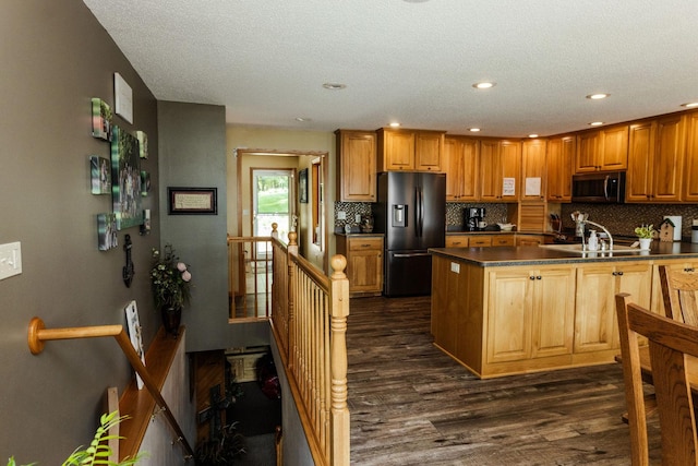 kitchen featuring tasteful backsplash, stainless steel appliances, a textured ceiling, dark hardwood / wood-style floors, and sink