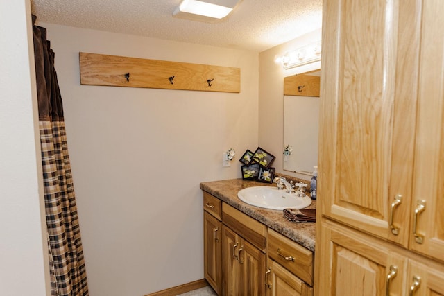 bathroom featuring a textured ceiling and vanity