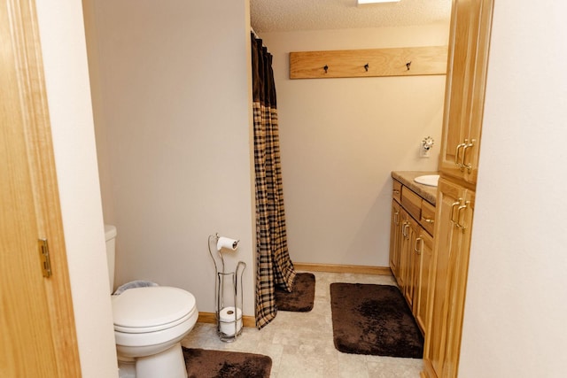 bathroom featuring vanity, toilet, and a textured ceiling