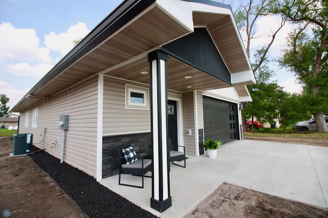 501 1st St NE, Hankinson, ND 58041 - view of property exterior featuring a garage, central air condition unit, and stone siding