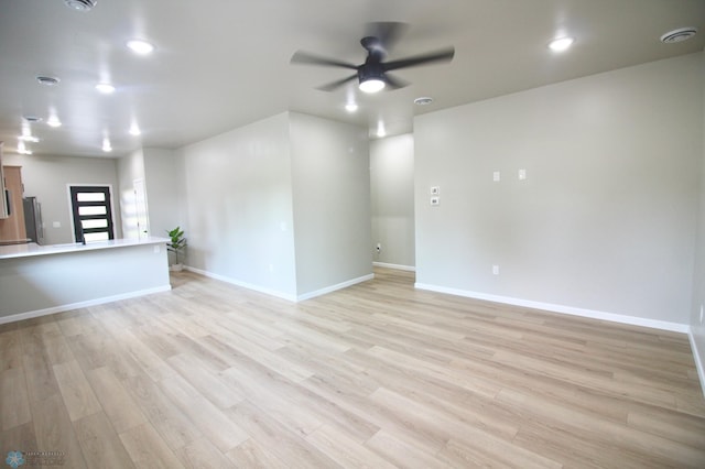 501 1st St NE, Hankinson, ND 58041 - unfurnished living room with light wood finished floors, a ceiling fan, and baseboards