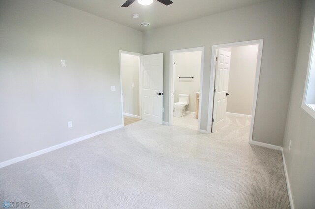 501 1st St NE, Hankinson, ND 58041 - unfurnished bedroom featuring connected bathroom, ceiling fan, light carpet, and baseboards