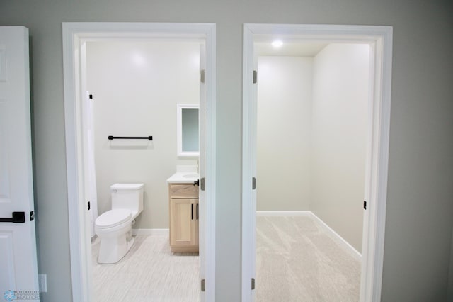 501 1st St NE, Hankinson, ND 58041 - bathroom featuring baseboards, toilet, and vanity