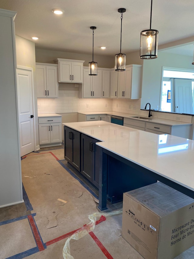 kitchen with tasteful backsplash, sink, pendant lighting, and white cabinets