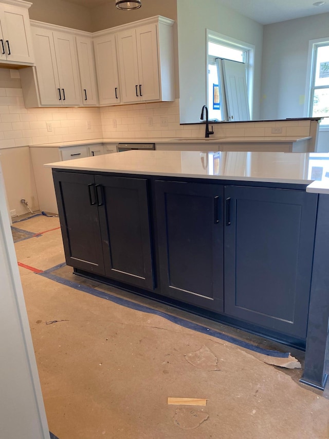 kitchen with decorative backsplash, white cabinets, dishwasher, and sink