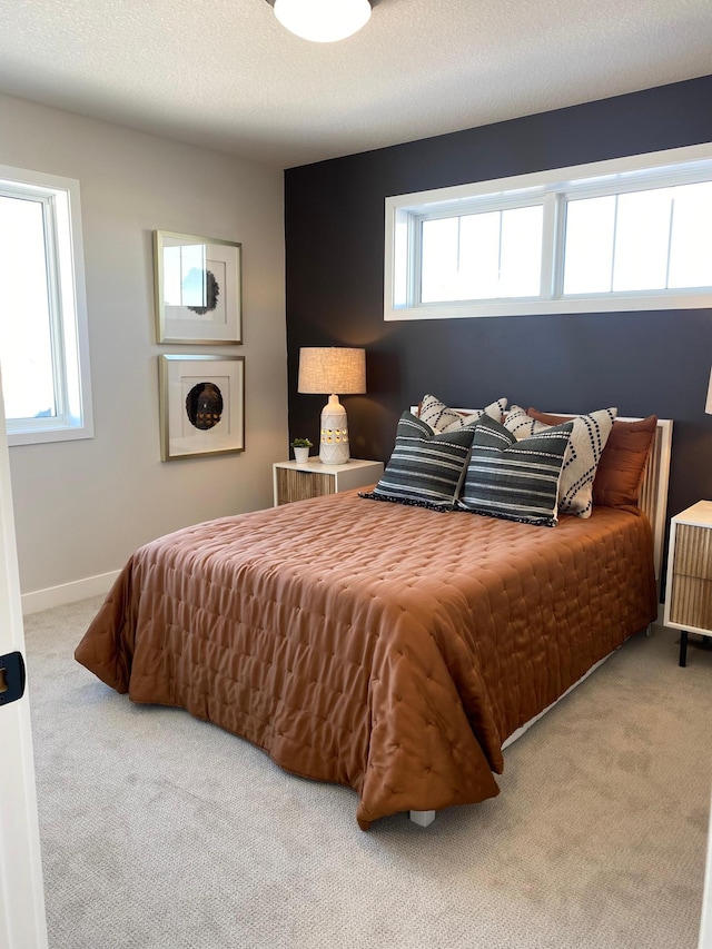 bedroom featuring multiple windows, carpet floors, and a textured ceiling