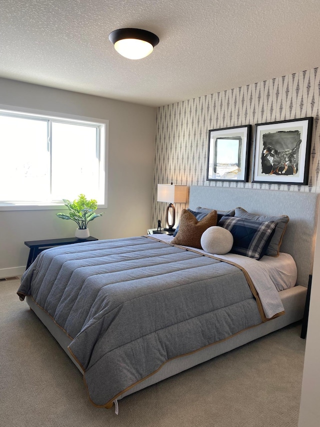 bedroom featuring carpet and a textured ceiling