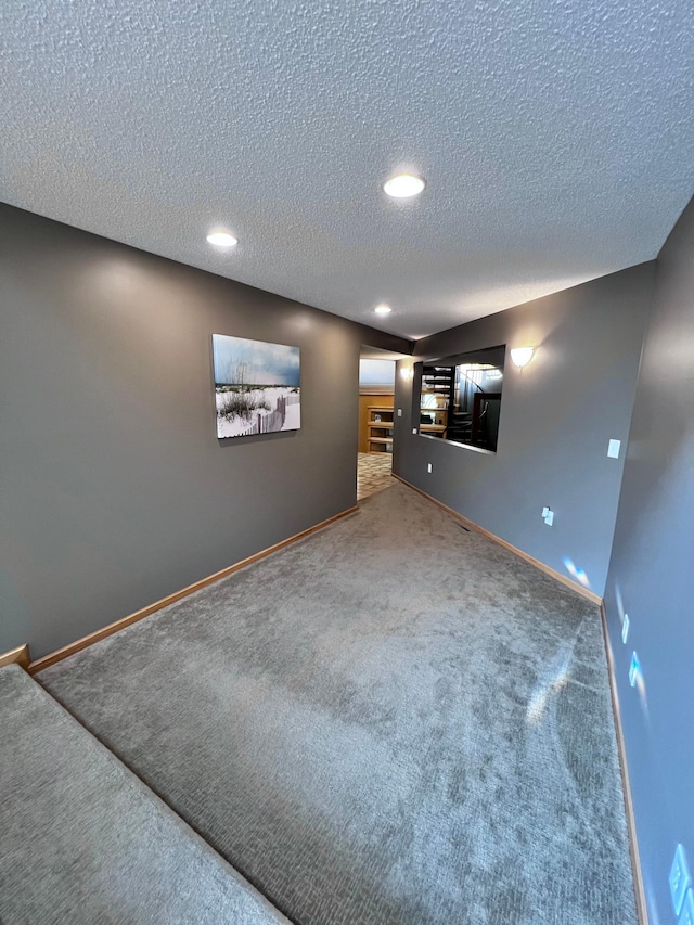 carpeted spare room featuring a textured ceiling