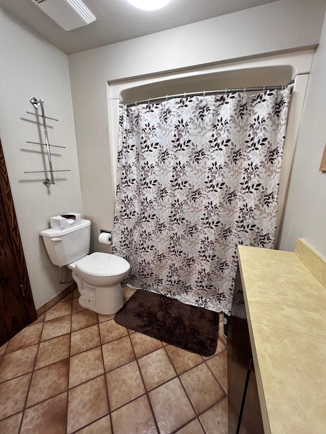 bathroom with toilet, vanity, and tile patterned floors