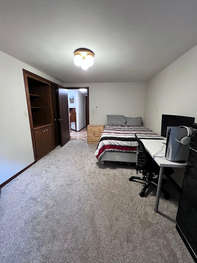 bedroom with a textured ceiling, a closet, and carpet flooring