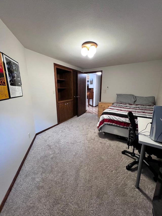 bedroom featuring a textured ceiling and carpet floors