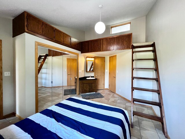 bedroom featuring a closet, a textured ceiling, and light tile patterned floors