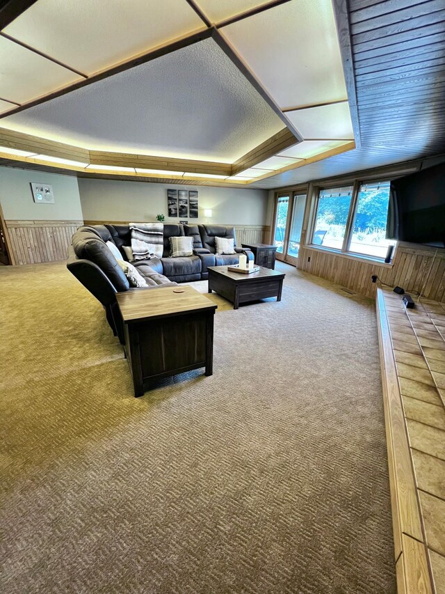 living room featuring carpet floors and a tray ceiling