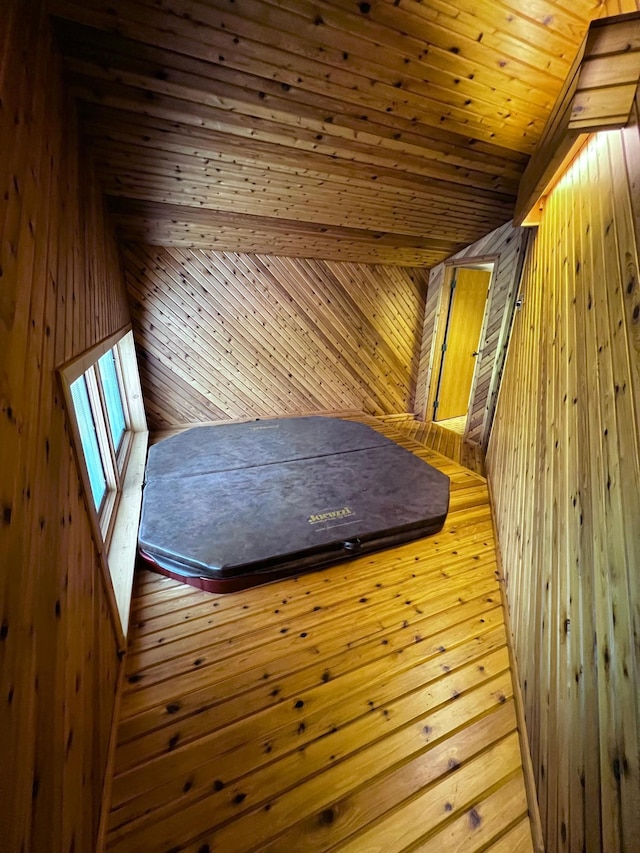 additional living space with wooden ceiling and wood walls