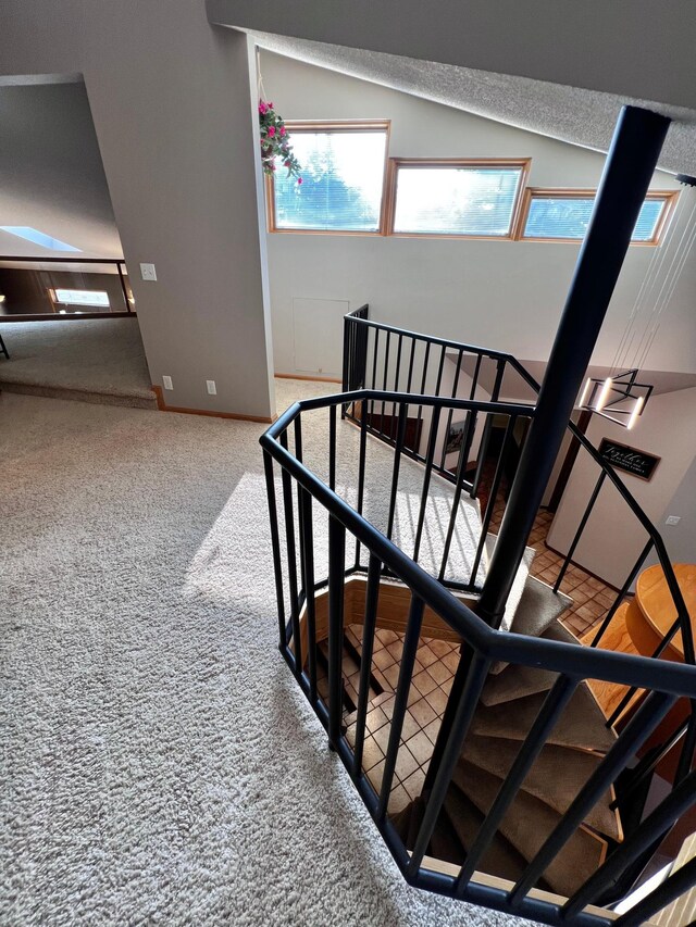 stairway with carpet flooring and lofted ceiling