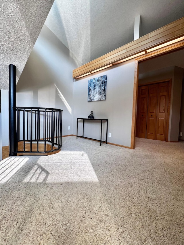 bonus room featuring a textured ceiling, lofted ceiling, and carpet flooring