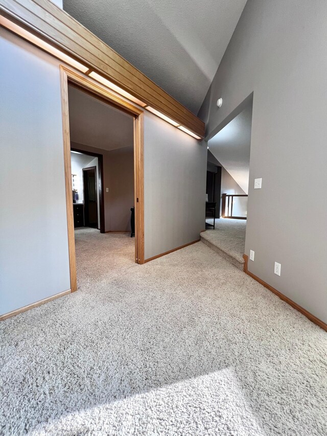 empty room featuring lofted ceiling and carpet flooring