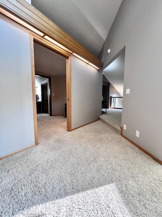 unfurnished room with carpet and lofted ceiling