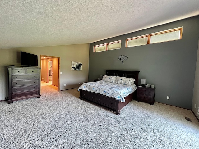 bedroom with a textured ceiling, light carpet, and lofted ceiling