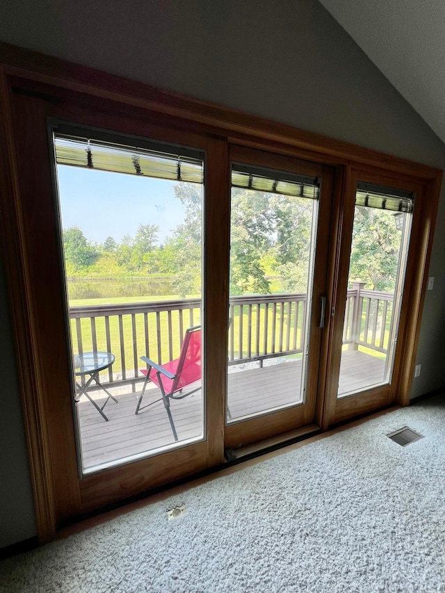 entryway with plenty of natural light, carpet flooring, and lofted ceiling