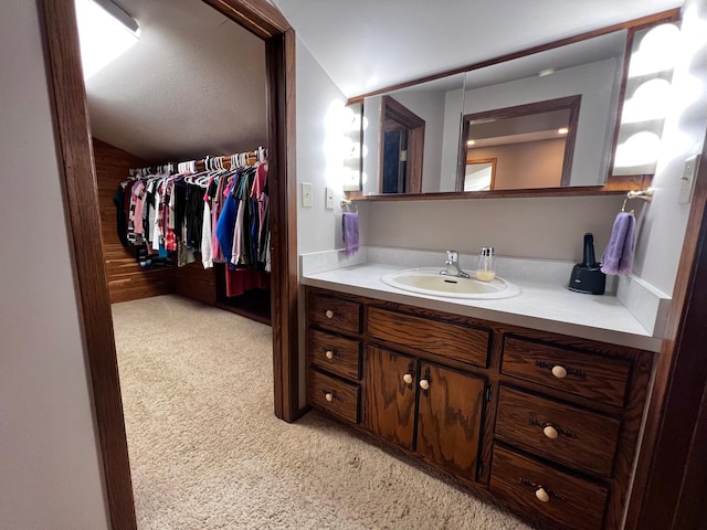 bathroom featuring vaulted ceiling and vanity