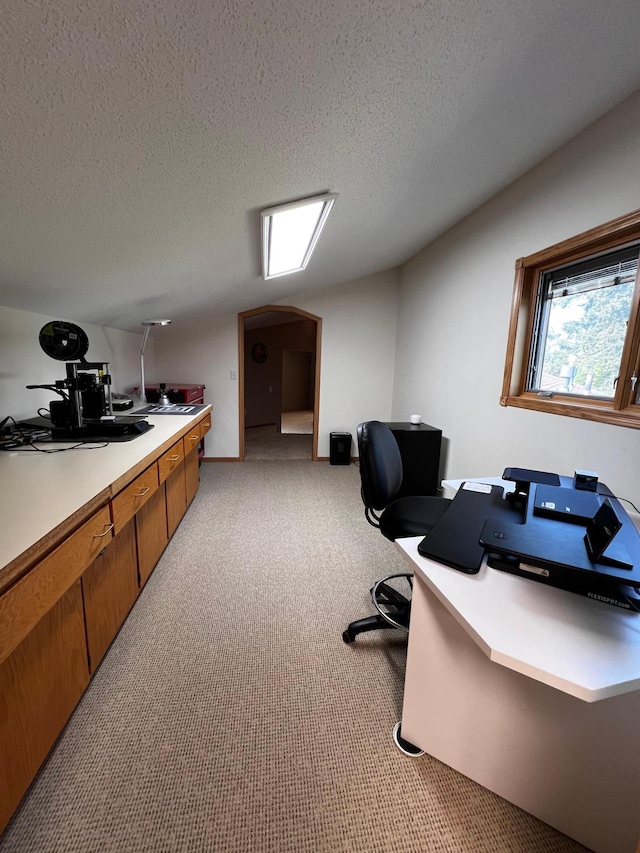 carpeted home office featuring a textured ceiling