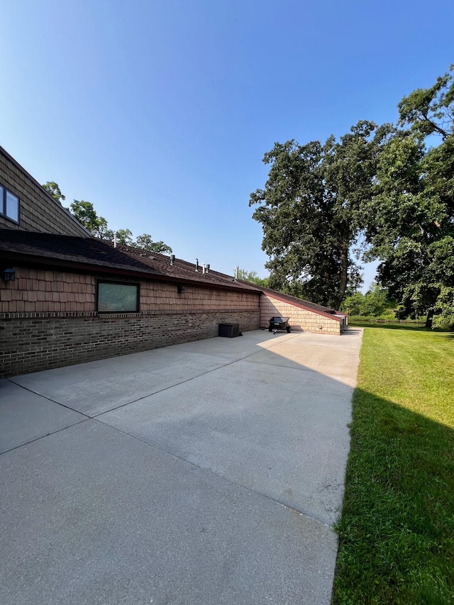 view of home's exterior with a patio area and a lawn