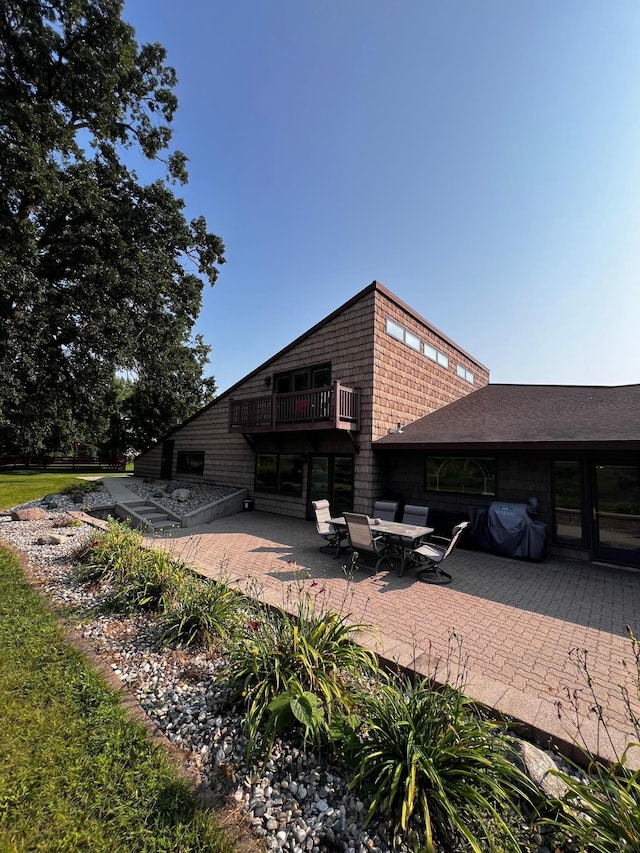 view of side of property featuring a patio area and a balcony