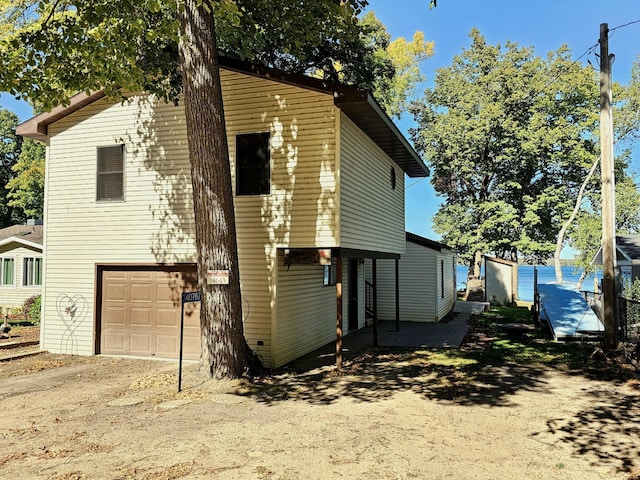 view of side of property featuring driveway and a garage