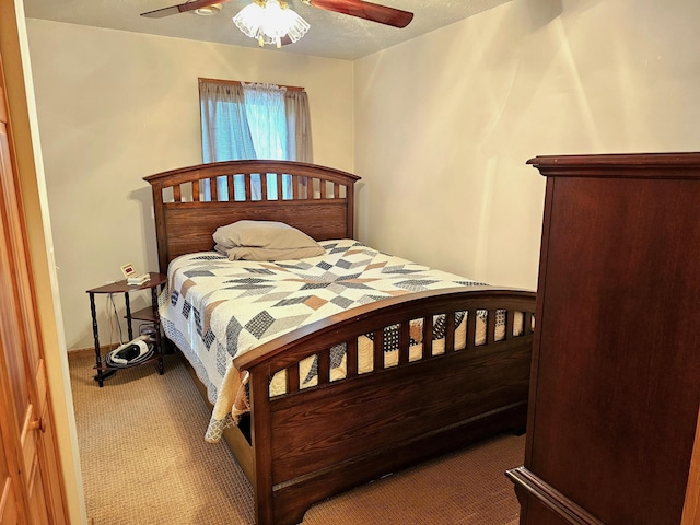 carpeted bedroom with a textured ceiling and a ceiling fan