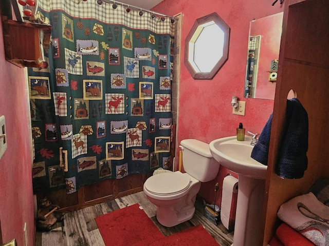 full bathroom with a shower with shower curtain, toilet, and wood finished floors