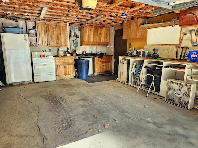 garage with washer / dryer, a workshop area, a garage door opener, and freestanding refrigerator