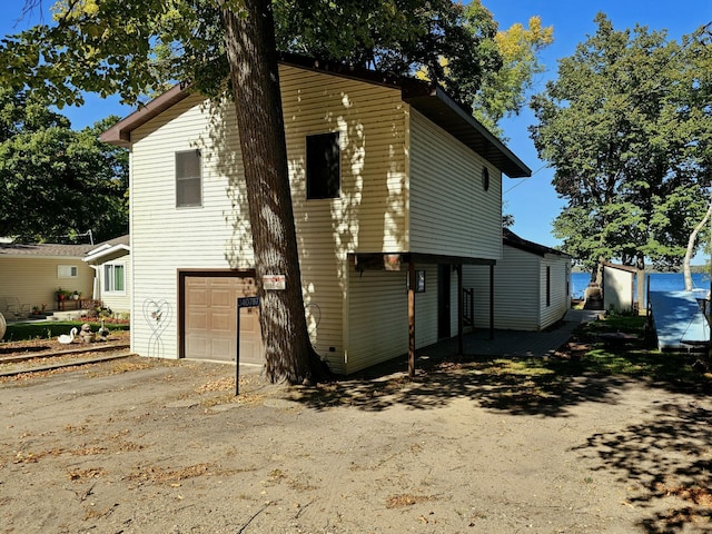 back of house with a garage and driveway